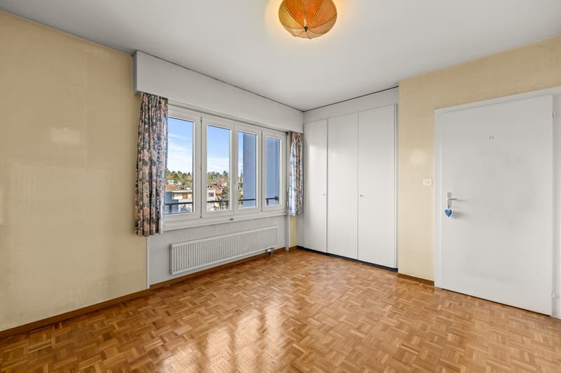 empty room, wooden floor, white walls, large windows, balcony, radiator, white wardrobes, white door