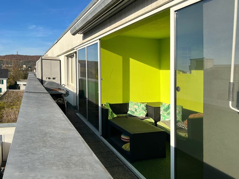 Balcony with a yellow wall, sofa set, coffee table, barbecue grill