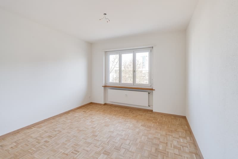 empty room, white walls, wooden parquet floor, large window, white radiator