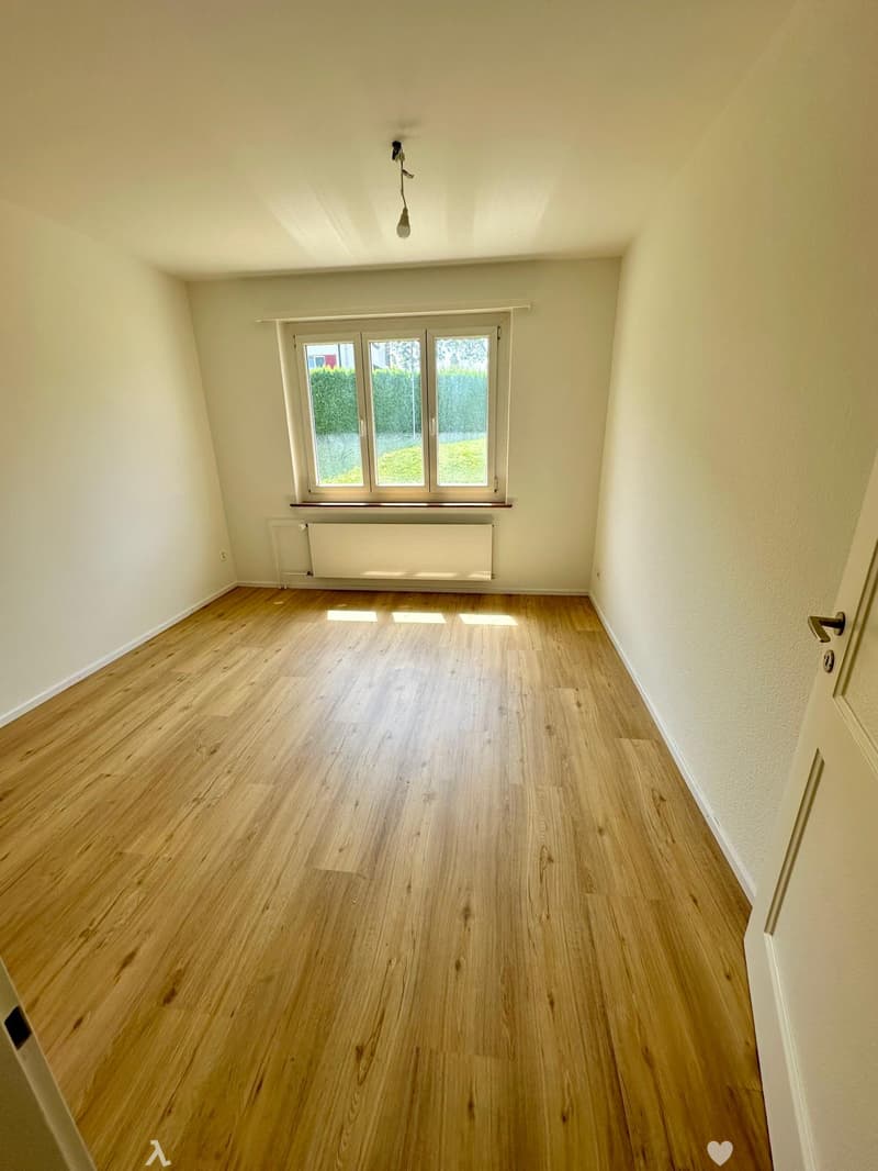 empty room, wooden floor, white walls, large window, radiator