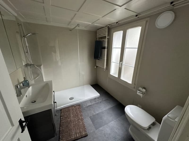Bathroom with shower, toilet, sink, and towel rack