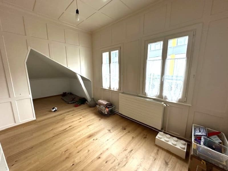 empty room, wooden floor, white walls, two windows, radiator, storage boxes