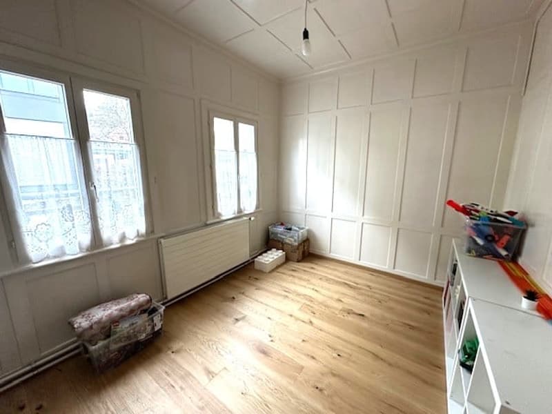 empty room, wooden floor, white walls, white ceiling, 3 windows, white curtains, white radiator, white shelves, storage boxes