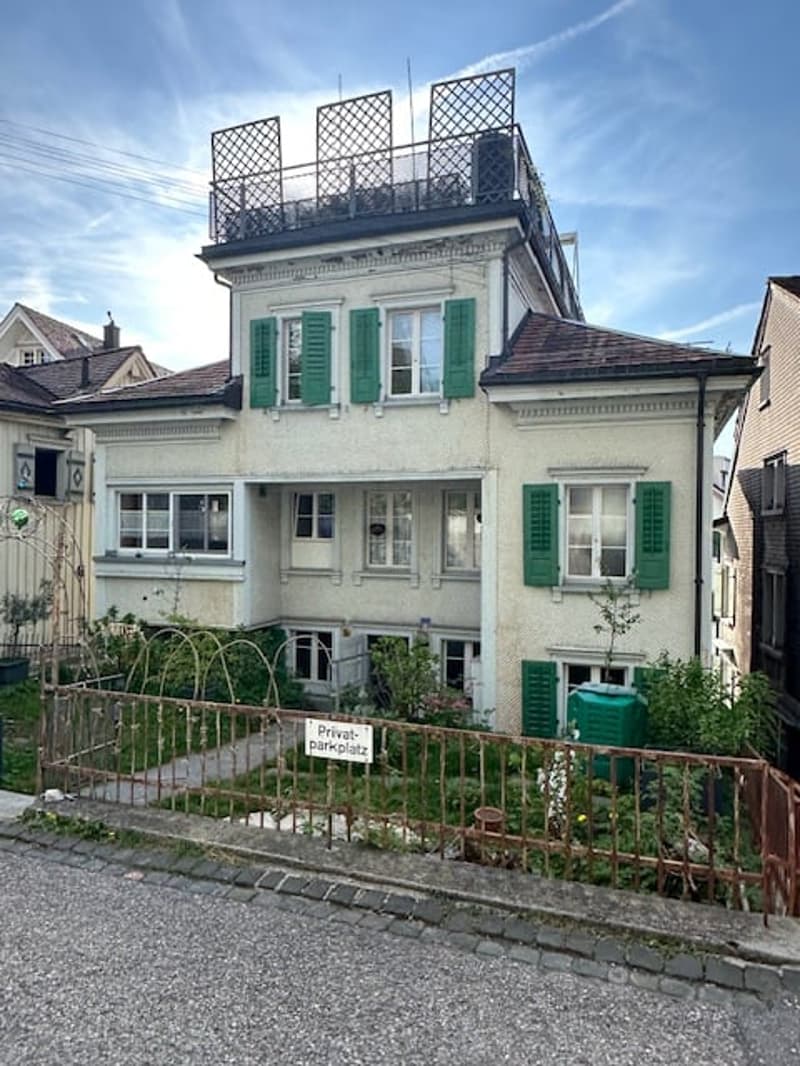 3 story house, white exterior, green shutters, brown roof, balcony, garden, fence
