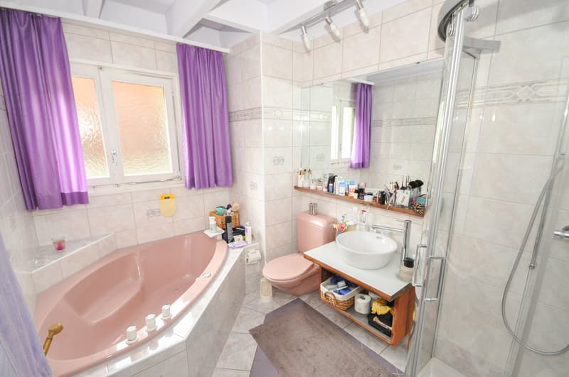 Bathroom with bathtub, shower, toilet, sink, and mirror.