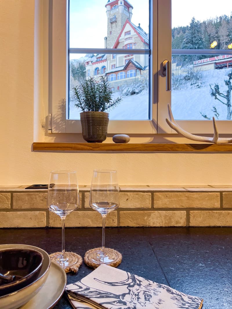 kitchenette with window, empty wine glasses, dish with bowl, folded napkins
