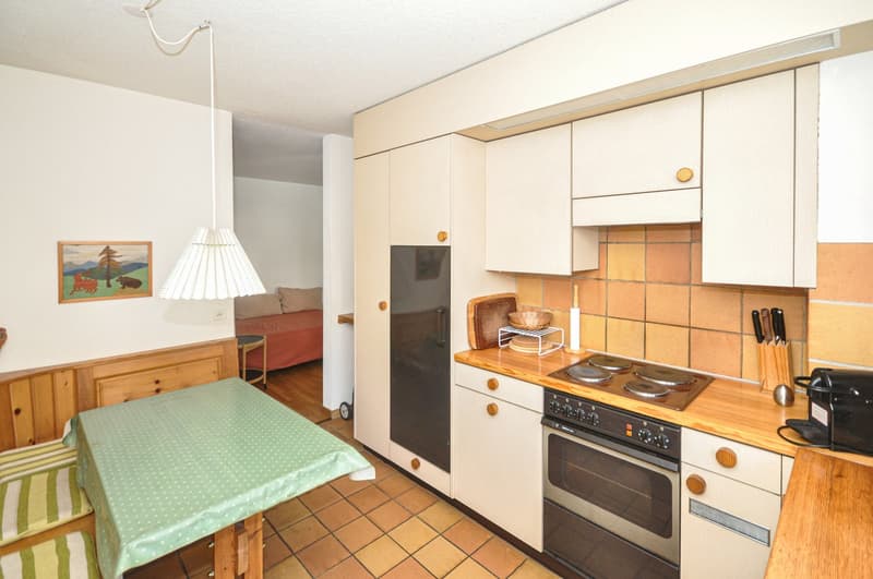 wooden cabinets, countertop, gas stove, oven, table, dining area, wooden flooring