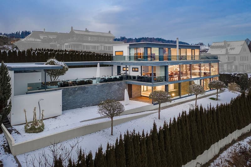 modern house with glass walls, multiple terraces, large windows, and a covered driveway