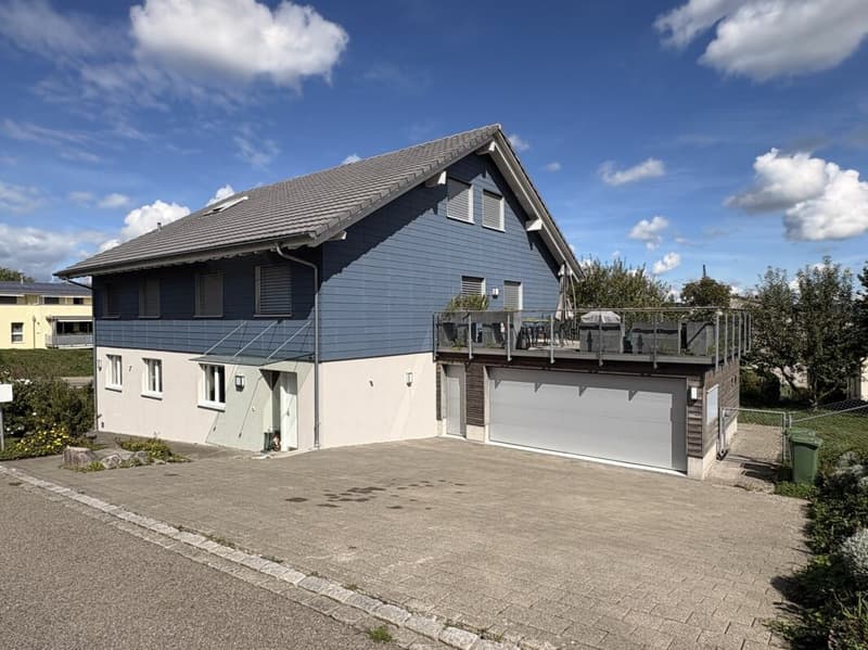 Ansicht mit Terrasse, Doppelgarage und Aussenfläche