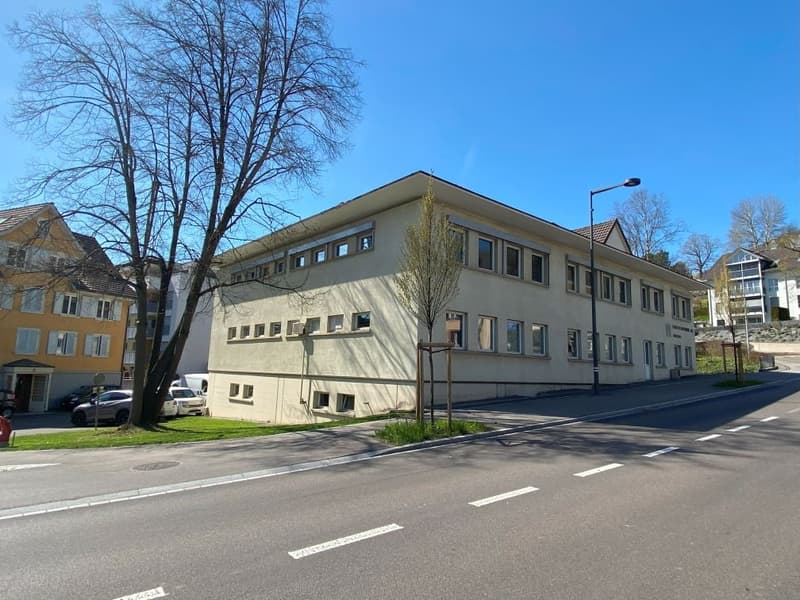 2 story beige building, 8 windows on each side, street in front