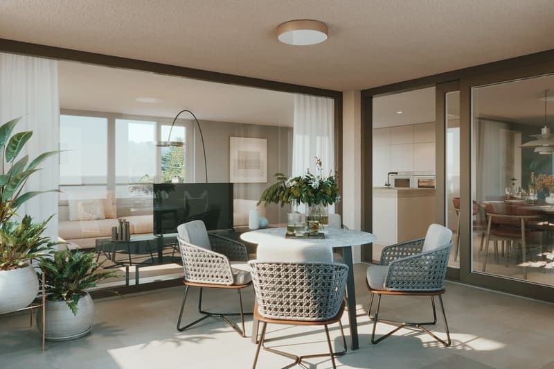 Dining area with a round table, chairs, and a glass wall with a view of the living room and garden