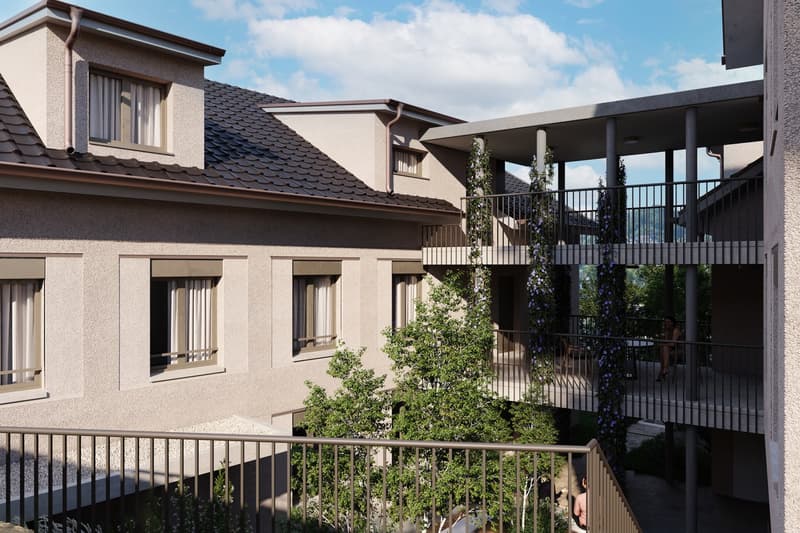Modern apartment building with balconies, multiple floors, and a central tree