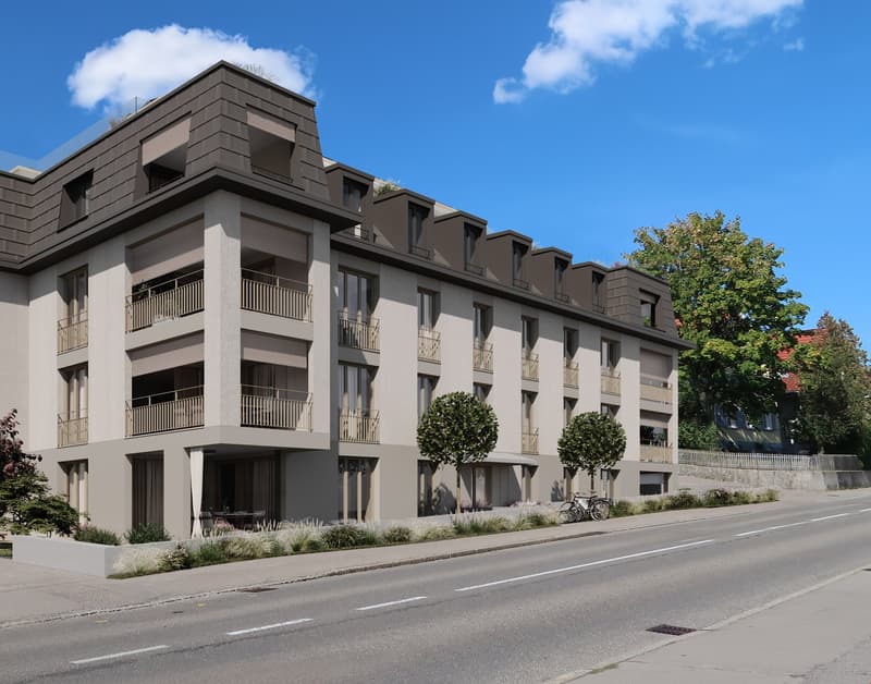 Modern apartment building with balconies, multiple floors, and a gray exterior