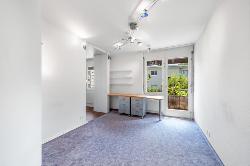 white walls, carpeted floor, desk, drawers, open door, natural light, window