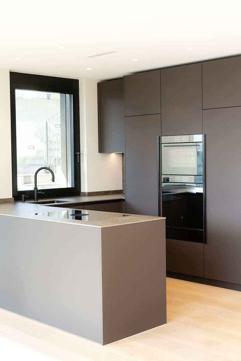 gray countertop, kitchen island, large sink, integrated oven and microwave, modern cabinetry, double sink
