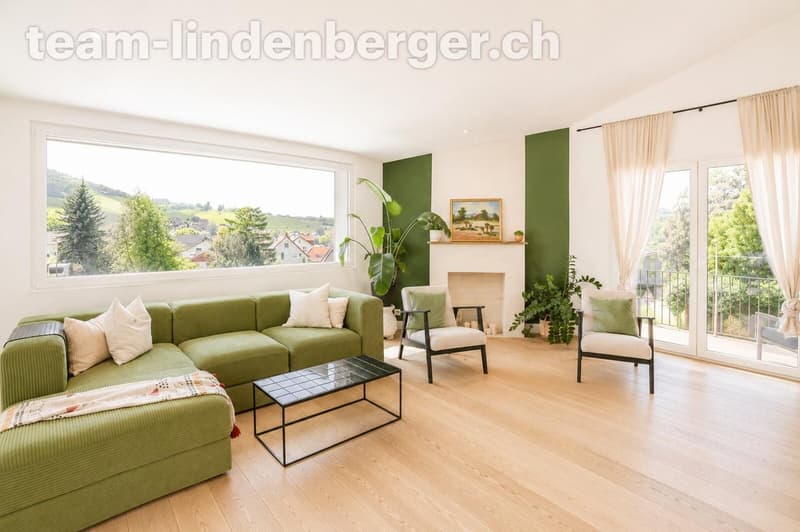 Wohnzimmer mit grossen Fenstern sowie Zugang zur Terrasse