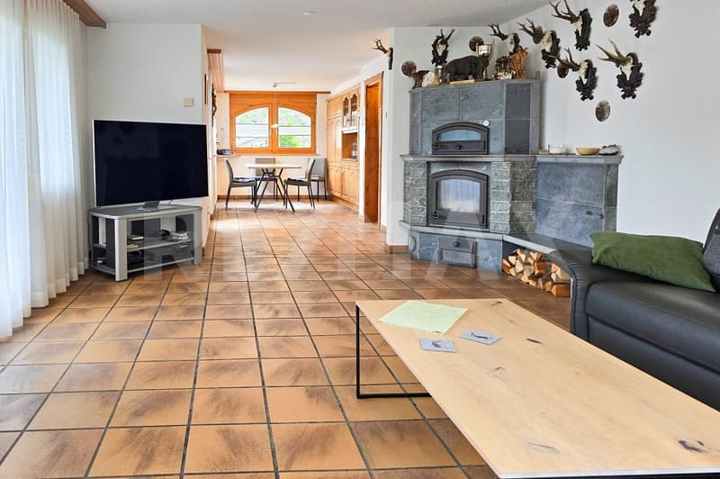 Fireplace, large windows, dining table, chairs, TV, entertainment center, couch, coffee table