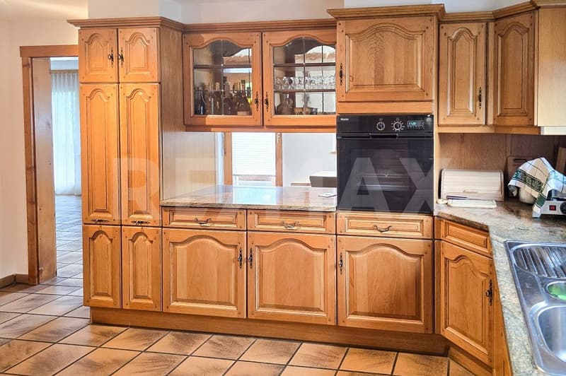modern kitchen with wooden cabinets, granite countertop, black oven, dishwasher, sink