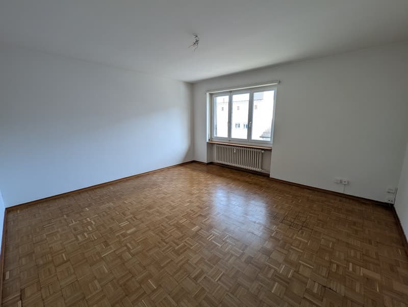 empty room, wooden parquet floor, white walls, large window, radiator