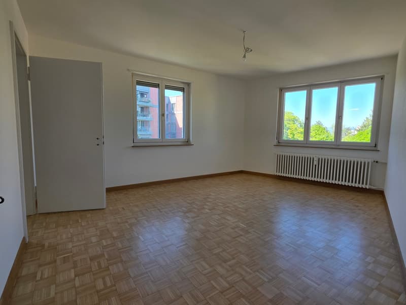 empty room, wooden floor, white walls, two windows, radiator