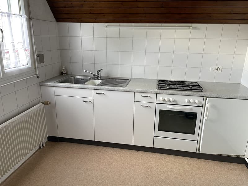 modern kitchen with white tiles, stainless steel sink, white oven and gas stove, white cabinets