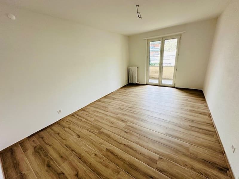 empty room, wooden floor, white walls, sliding glass door, balcony, radiator