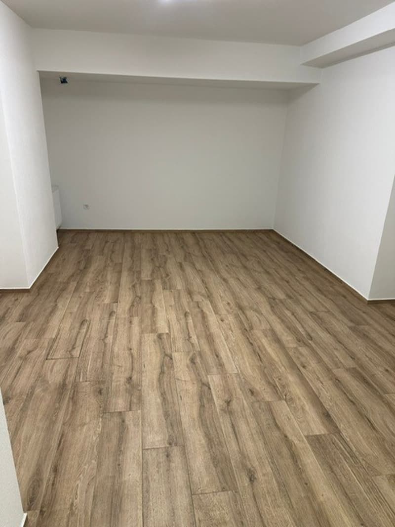 empty room, wooden floor, white walls, power outlet