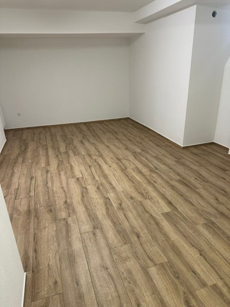 empty room, wooden floor, white walls, power outlet
