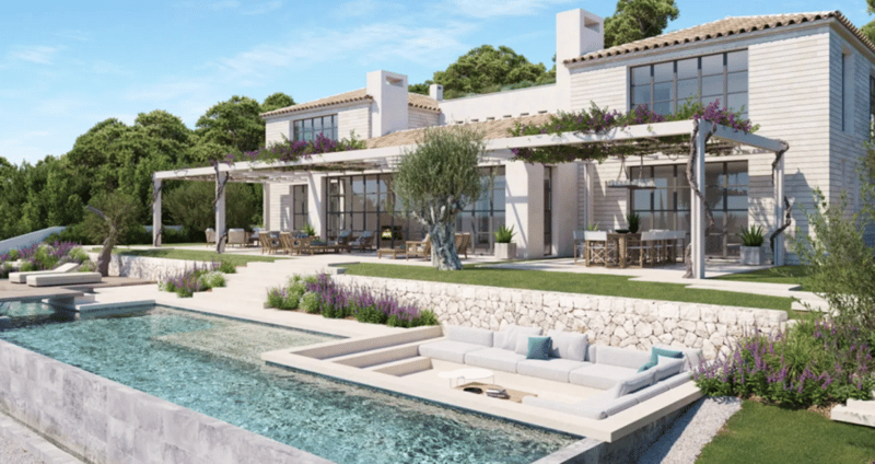 Large two-story Mediterranean-style villa with a swimming pool, outdoor lounge area, and balconies. The house has a stone facade, large windows, and a tiled roof. The landscaping includes lush greenery, flowering plants, and a stone retaining wall around
