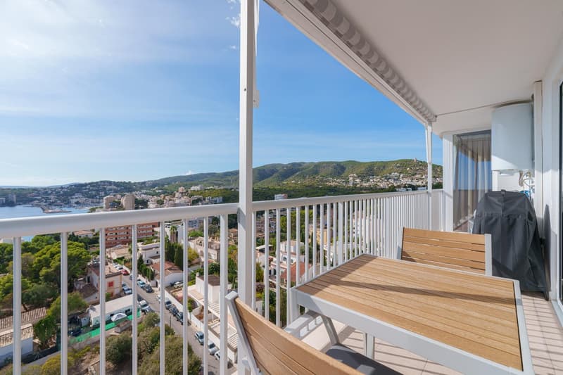 Spacious balcony with a panoramic view of the city and surrounding hills. The balcony features a wooden deck and railing, providing an outdoor living space with a scenic overlook.