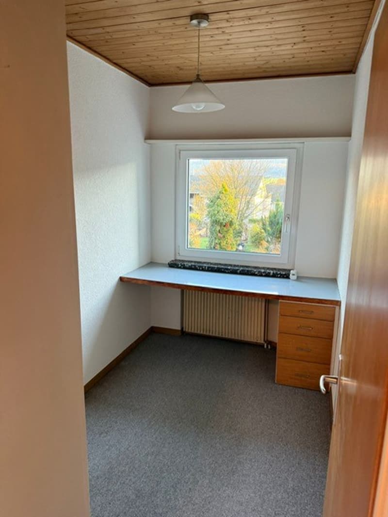 small room with desk, window, radiator, carpet