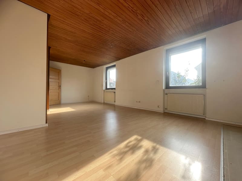 empty room, wooden floor, white walls, wooden door, 2 windows, radiators