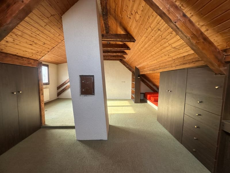 wooden beams, radiator, two sets of built-in wardrobes, central pillar, carpet floor, small sleeping area
