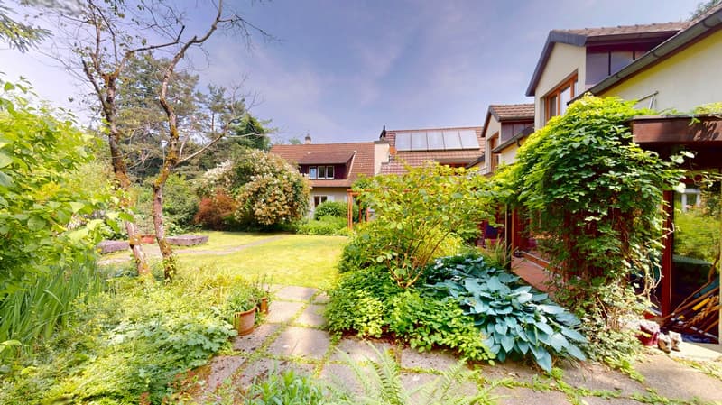 lush garden with plants, trees, and a pathway leading to a covered area