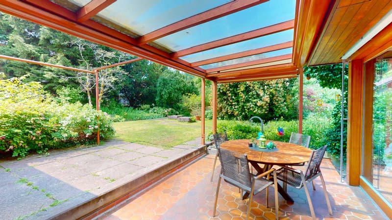 covered patio, wooden frame, tile floor, table and chairs, plants, garden in background