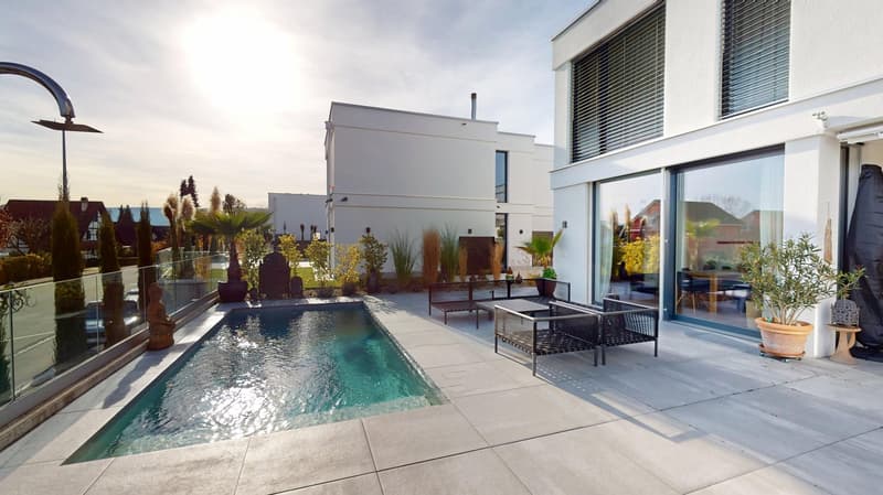 small swimming pool, plants, modern outdoor furniture, view of street and buildings