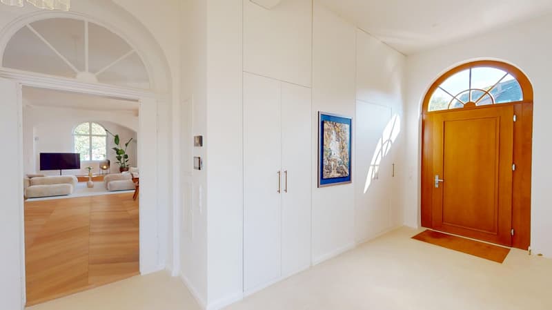 minimalist interior, white walls, wooden floor, arched doorway, wooden door, picture frame, small rug