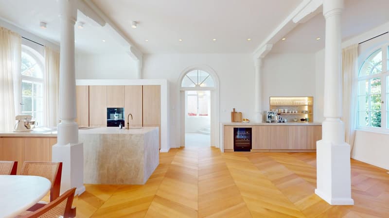 wood floor, large center island, white and wooden cabinets, arched doorway, bright natural lighting