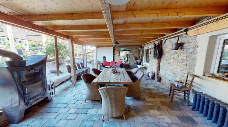 outdoor dining area, large wooden table, chairs, radiators, stone walls, wood ceiling, open patio