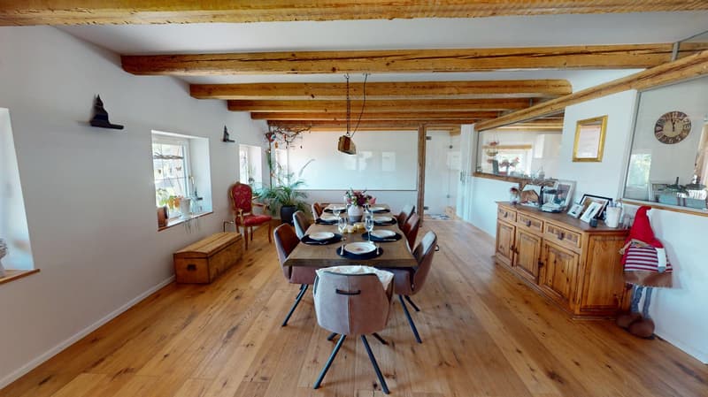 Dining room with wooden floor, wooden beams, dining table, and wooden cabinet