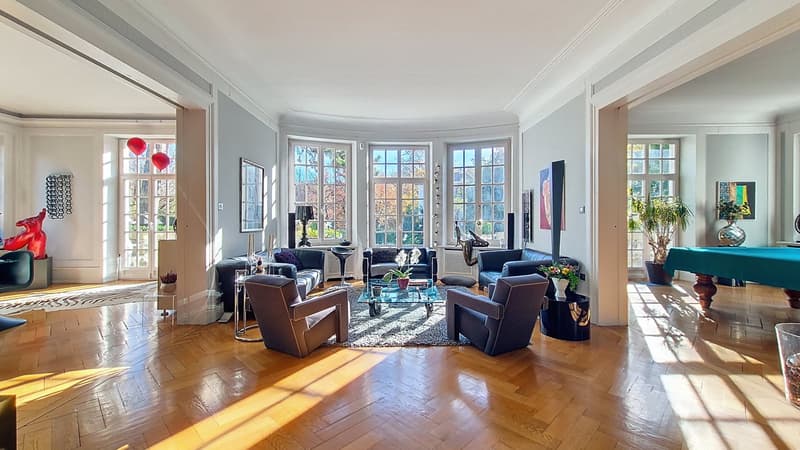 spacious open floor plan, hardwood floors, round seating area, large windows, modern artwork