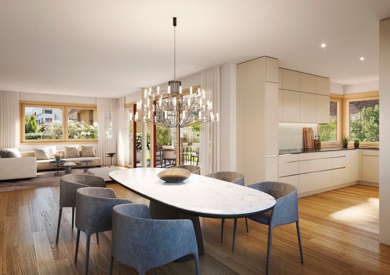 Dining area with a large oval marble table, modern chandelier, and six chairs. The room has wooden floors and large windows with curtains. The kitchen is visible in the background with a modern design.
