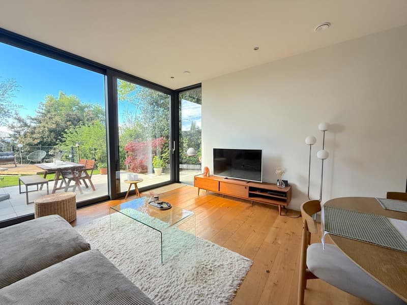 large windows, balcony, wooden floor, glass coffee table, TV, couch, dining table, chairs