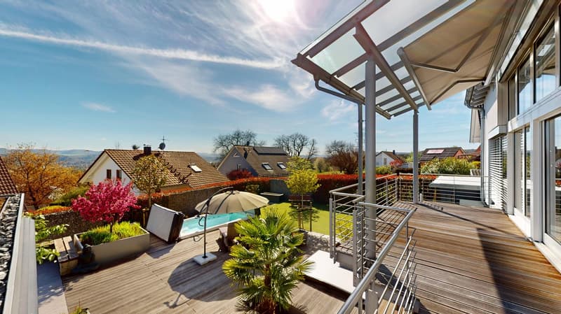 Terrace with wooden deck, swimming pool, plants, trees, mountains in the distance