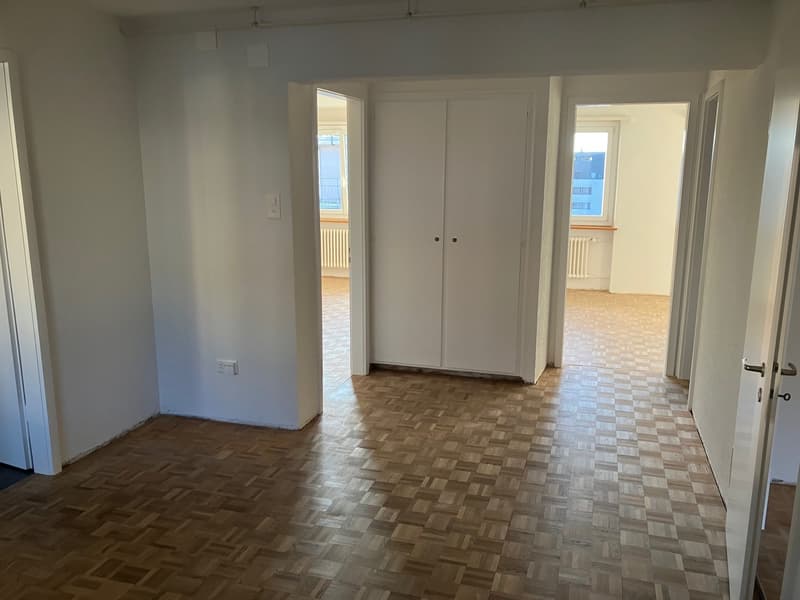 empty room, wooden floors, 2 double doors, open rooms with windows at the end