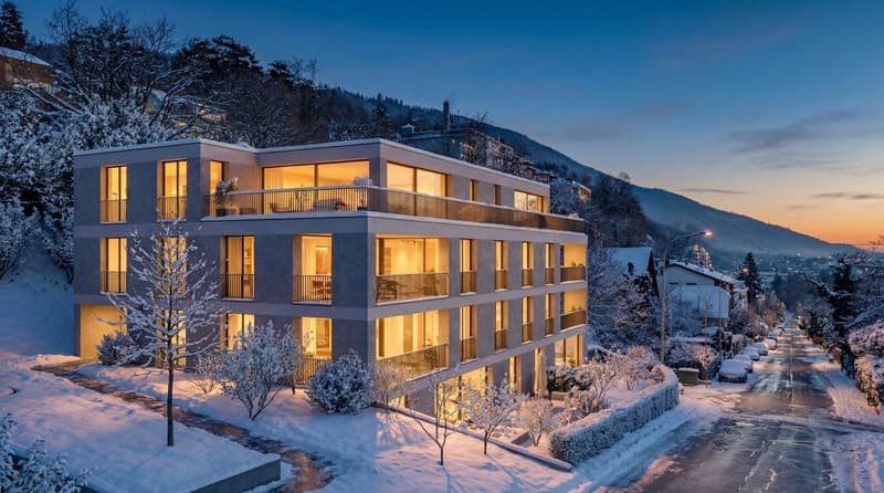 Multistory building, grey exterior, glass windows, multiple balconies, snowy surroundings, mountain view