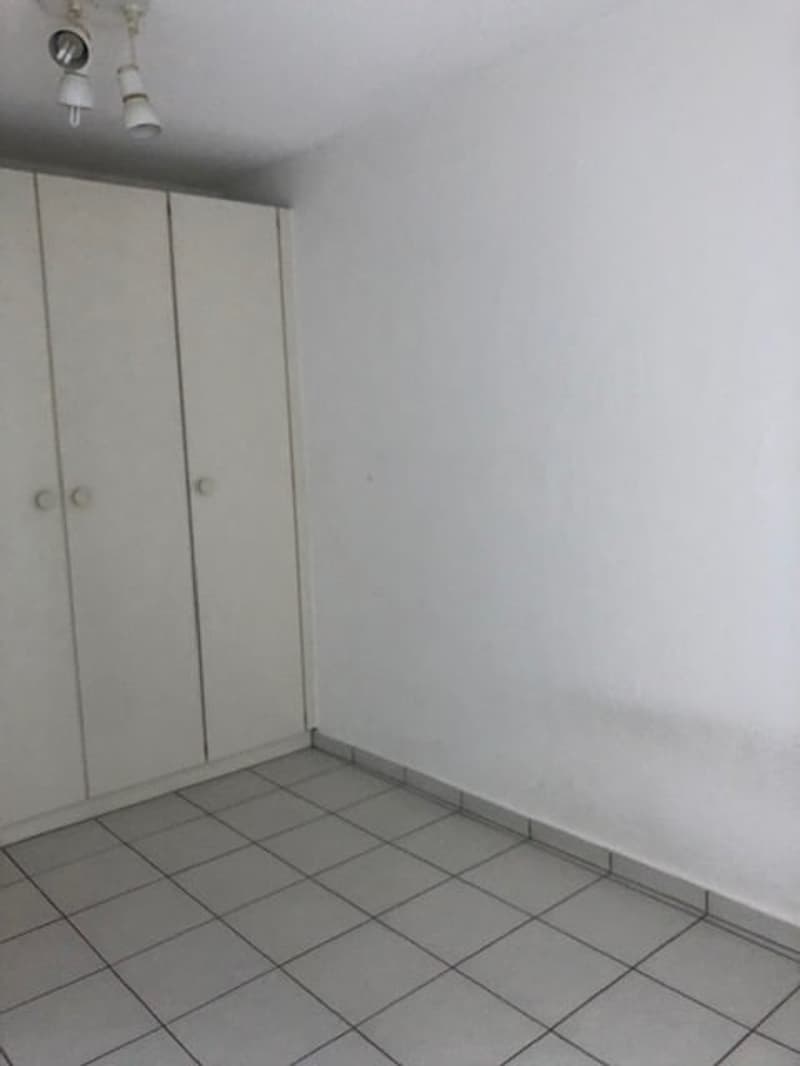 empty room with white tile floor, white wardrobe, three lights on ceiling