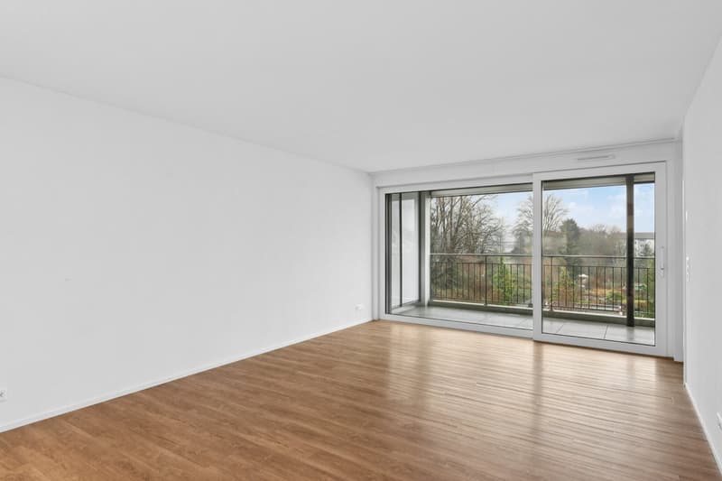 empty room, white walls, wooden floor, sliding glass doors to balcony