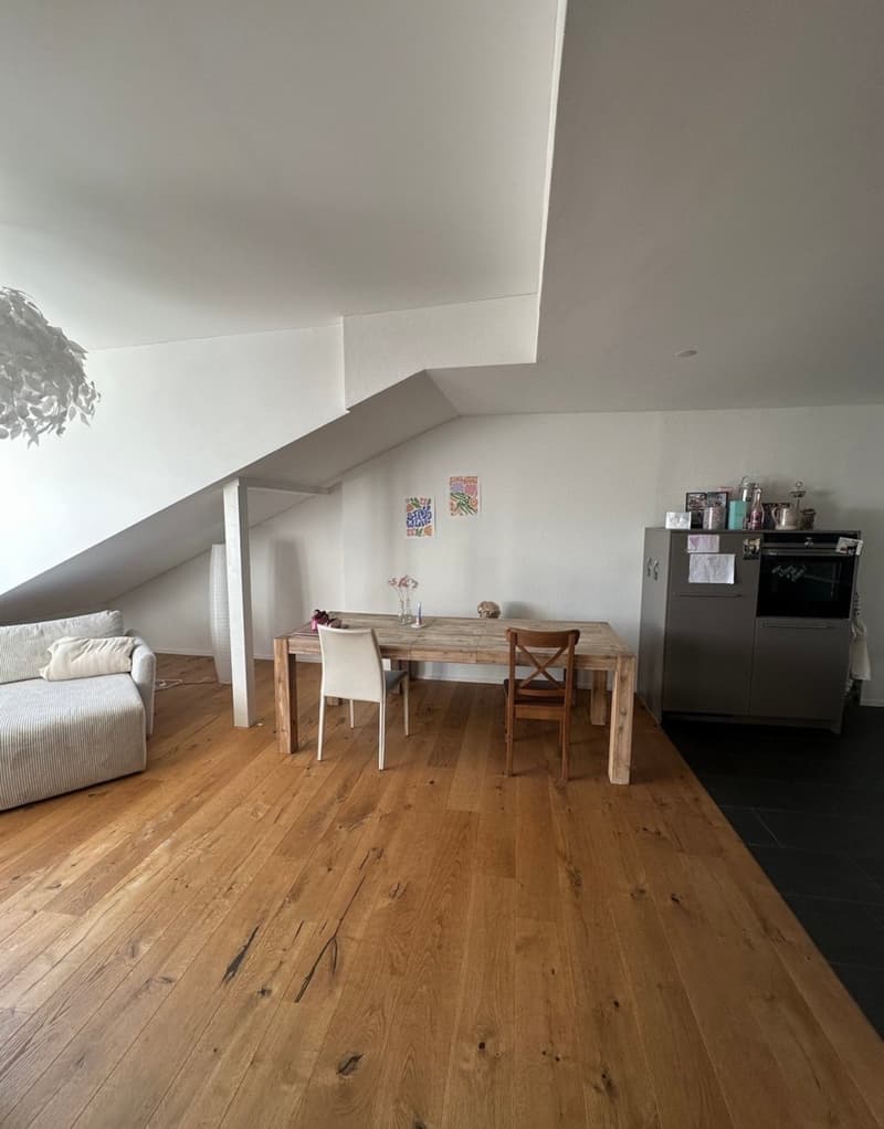 wooden floor, dining table, chairs, couch, white walls, ceiling lamp, white pillar, kitchen cabinet, oven