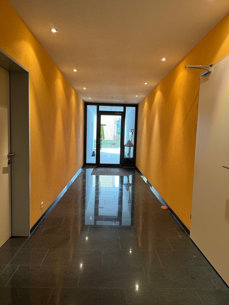 Tiled floor, yellow walls, two doors, a door leading to a patio with a shovel, two doorways